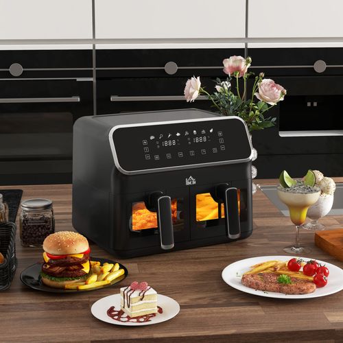 Black air fryer on a kitchen counter with food and flowers in the background