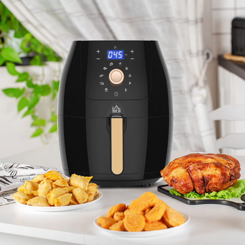 Black air fryer with cooked food on a kitchen counter