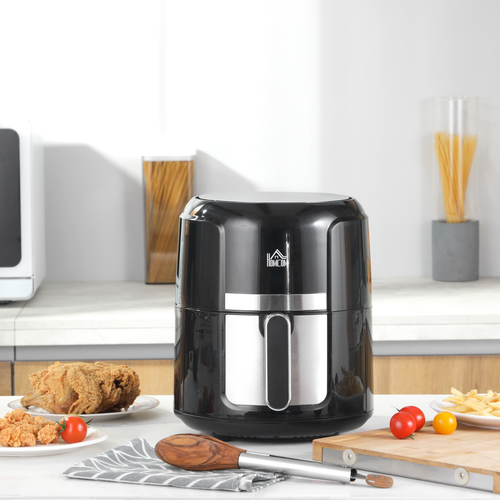Black air fryer on a kitchen counter with food items around