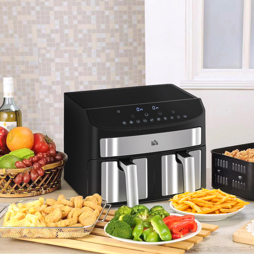 Black and silver air fryer on a kitchen counter with various foods around it.